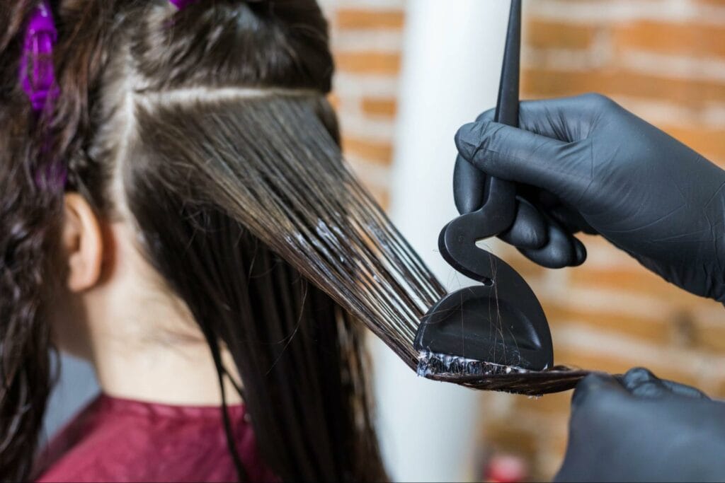 applying liquid keratin using a special hairdressing brush